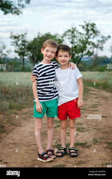 Two happy little kids boys embracing in rural settings. Funny children ...