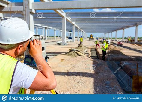 Civil Engineer Geodesist Is Working With Total Station On A Building