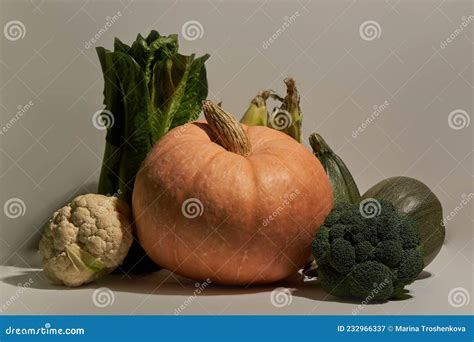 Verduras Estacionales En Mesa Blanca Y Pared Blanca Imagen De Archivo