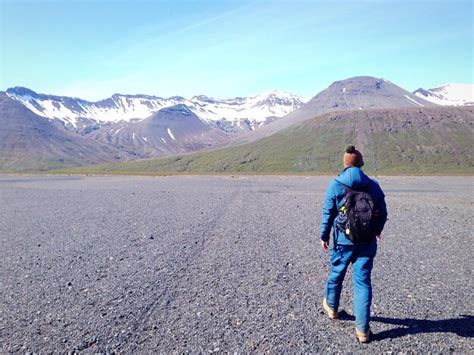 Premium Photo Rear View Of Hiker Walking On Field Against Mountains