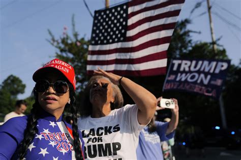 Dozens of Trump supporters cheer him on as he turns himself in at ...