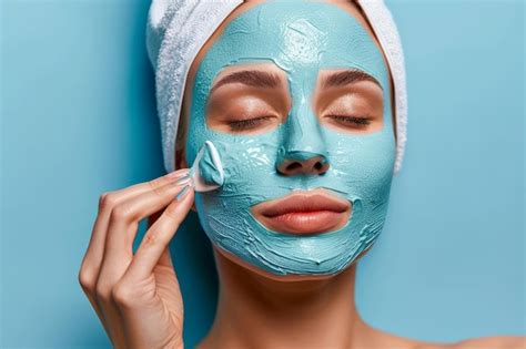 Premium Photo Woman Applying Turquoise Facial Mask For Skincare