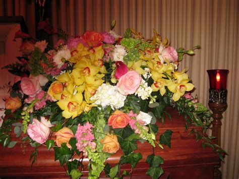 A bold and colorful casket spray with cymbidium orchids, calla lilies ...