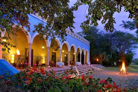 An Outdoor Area With Flowers And Candles Lit Up At Night In Front Of A