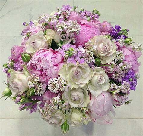 A Bouquet Of Pink And White Flowers In A Vase On A Marble Flooring Area