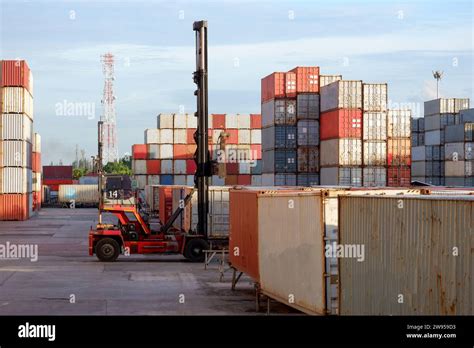 Forklift Handling Goods Container Boxes In Logistics Yard With Stack