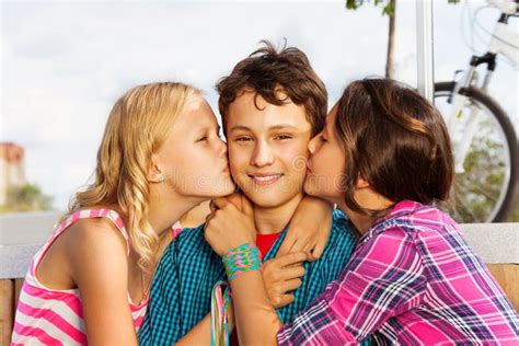 Dos Muchachas Hermosas Que Besan La Sonrisa Un Muchacho Lindo Foto De