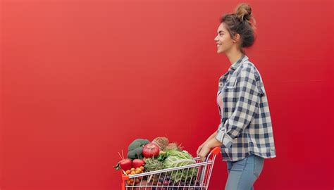 Premium Photo Woman Pushing Shopping Cart Full Of Food On Red Background