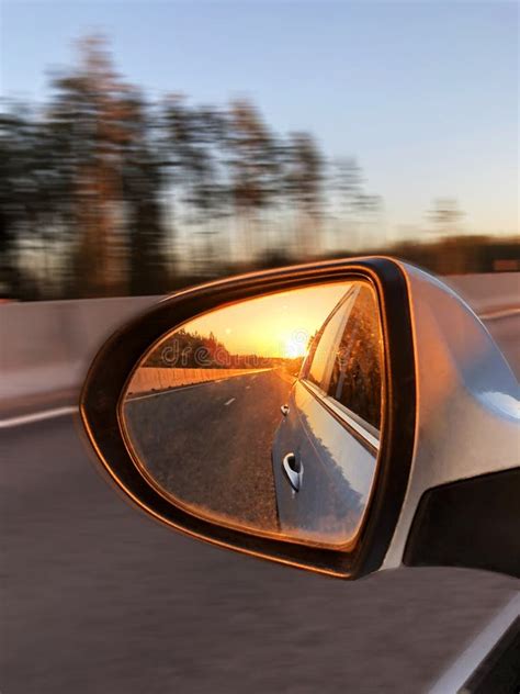 A Reflexão No Espelho Retrovisor Do Carro E a Estrada Iluminam se