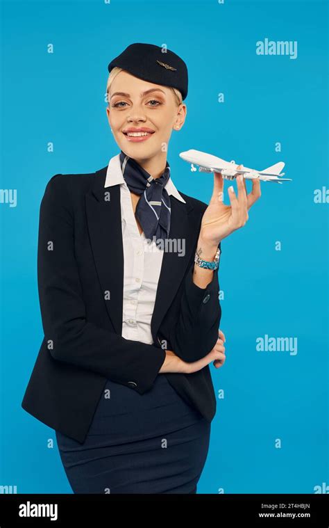 Joyous Air Hostess In Uniform Of Commercial Airlines Posing With