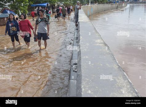 Residents Wade Through A Waterlogged Area In Kampung Melayu East