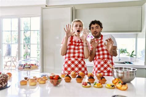 Couple Of Wife And Husband Cooking Pastries At The Kitchen Afraid And Terrified With Fear