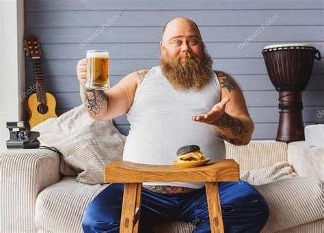 Male Fatso Drinking Beer At Home — Stock Photo © Iakovenko123 136846128