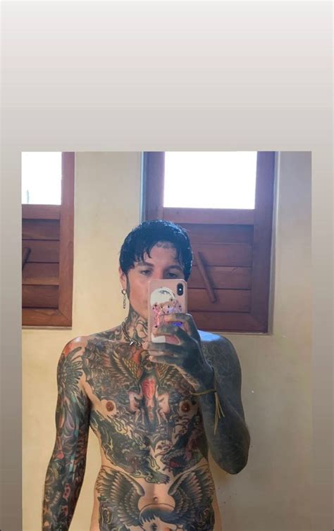 A Tattooed Man Taking A Selfie With His Cell Phone