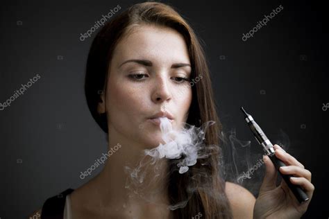 Elegant woman smoking e-cigarette with smoke Stock Photo by ...