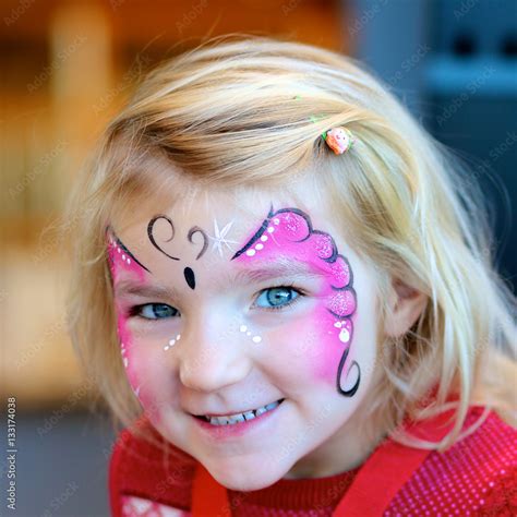 Cute little girl getting her face painted like a butterfly by face ...