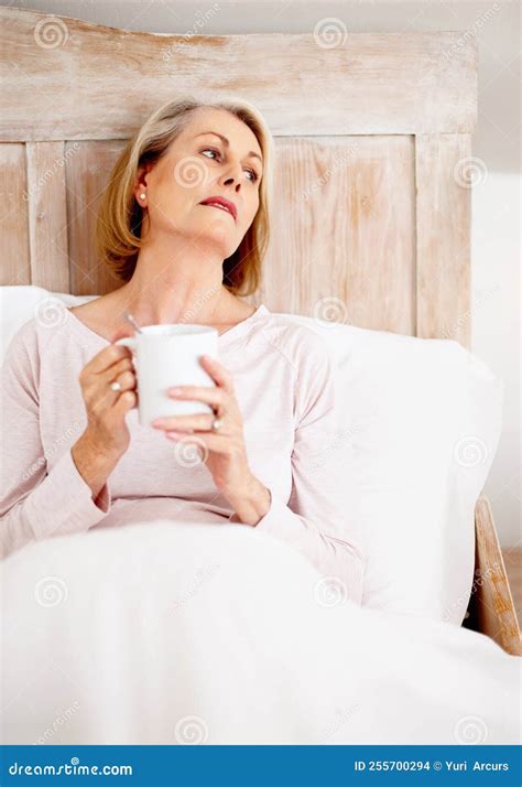 Relaxed Mature Woman Holding Coffee Mug In Bed Portrait Of A Relaxed