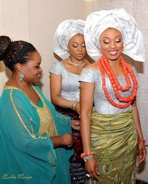 Three Women Dressed In Traditional African Clothing Standing Next To