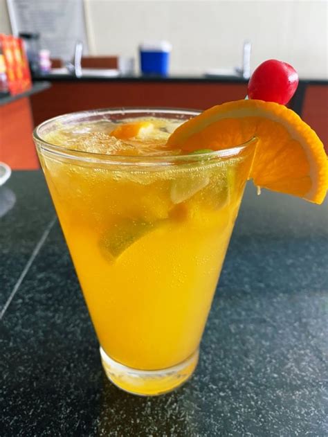 a glass filled with orange juice and garnished with an orange slice ...