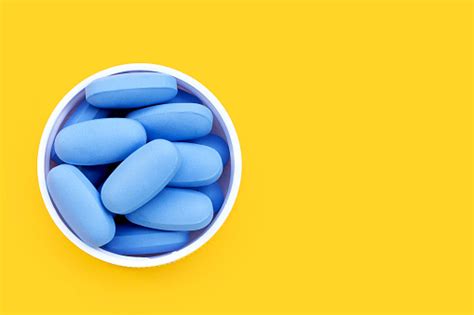 Prep 파란색 알약은 노란색 배경에 플라스틱 병 뚜껑에 Hiv 블루 알약을 예방하는 데 사용됩니다 건강관리와 의술에 대한 스톡