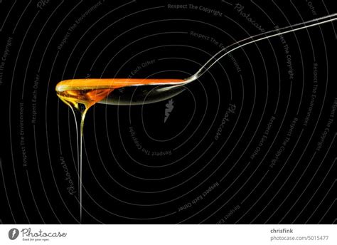 Honig Tropft Von L Ffel Vor Schwarzem Hintergrund Ein Lizenzfreies
