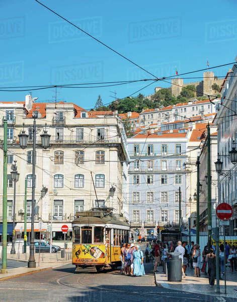 Traditional Yellow Tram At Praca Da Figueira With Castelo Sao Jorge At