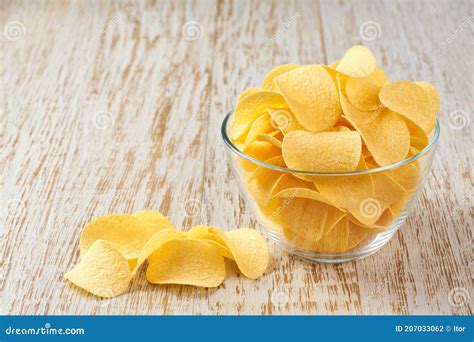 Potato Chips In A Transparent Glass Bowl On A Wooden White Table Stock