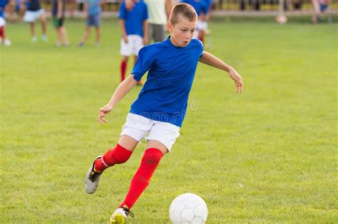 Meninos Que Jogam O Jogo De Futebol Do Futebol No Campo De Esportes