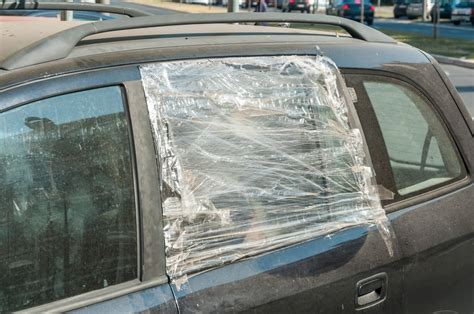 Broken Side Window Of The Car With Plastic Tape Over It To Protect The