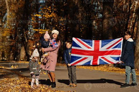 National holiday of United Kingdom. Family with british flags in autumn
