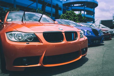 Orange Bmw Car Beside Blue Bugatti Car · Free Stock Photo