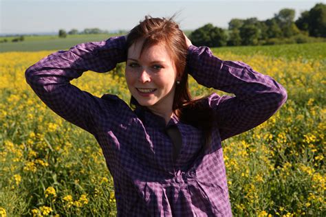 Redheaded Teen Pauses For A Moment Before Getting Naked In A Field Of