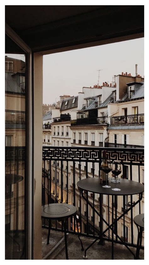 A Balcony With Tables And Chairs Overlooking The City