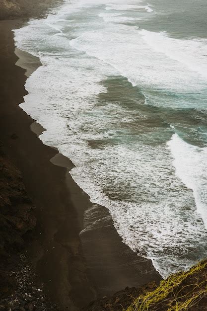 Ondas fortes batendo em penhascos íngremes da costa vulcânica trilha de