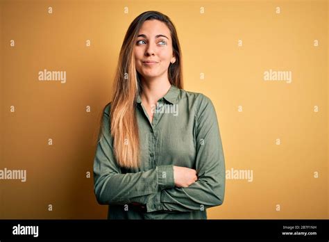 Young Beautiful Blonde Woman With Blue Eyes Wearing Green Shirt Over