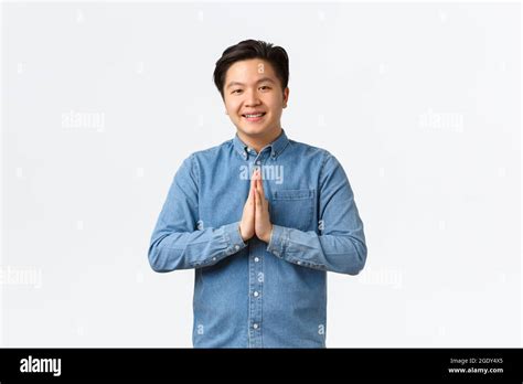 Smiling Handsome Young Asian Man Looking Thankful And Pleased Holding