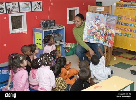 Preschool teacher reading a book to her students Stock Photo - Alamy