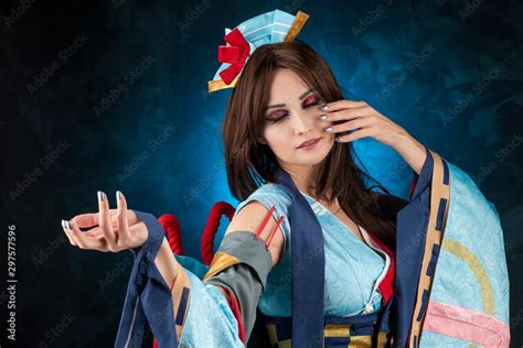 Beautiful Smiling Leggy Busty Cosplay Girl Wearing A Stylized Japanese Kimono Costume Cheerfully