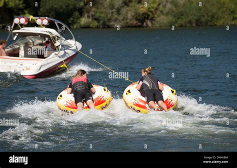 Two Teenage Girls Ride Inflatable Donut Being Pulled By A Speedboat On