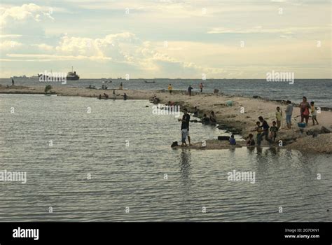 Jakarta, Indonesia. People having recreational time on the beach of Cilincing, overlooking ...