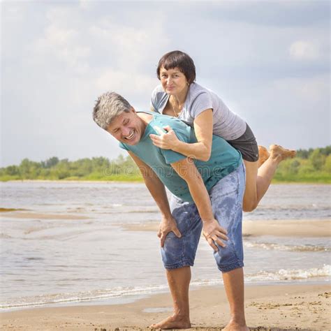 Beautiful Sportive Couple Running On The Water Along The Wild Beach