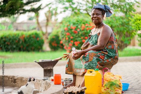 Image Of Beautiful African Mother Sitting Outside Cooking Cheerful