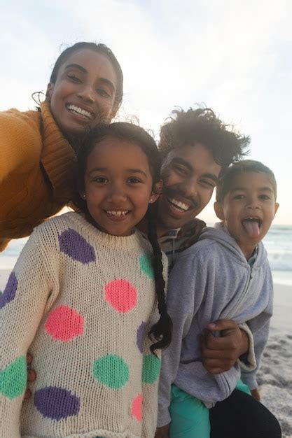 Retrato de família multirracial feliz tirando selfie durante o pôr do