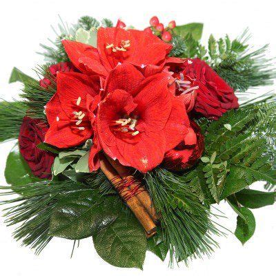 A Bouquet Of Red Flowers And Greenery On A White Background