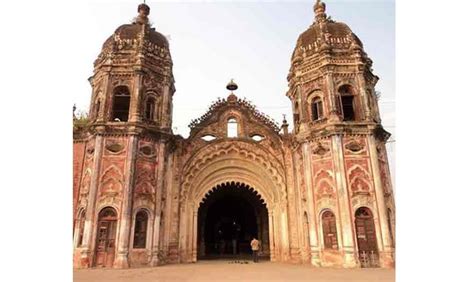 An Old Building With Two Towers And Arches