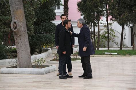 Two Men Standing Next To Each Other Near Trees