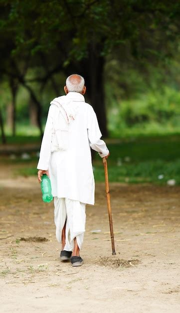 Premium Photo Indian Old Man Walking With A Stick