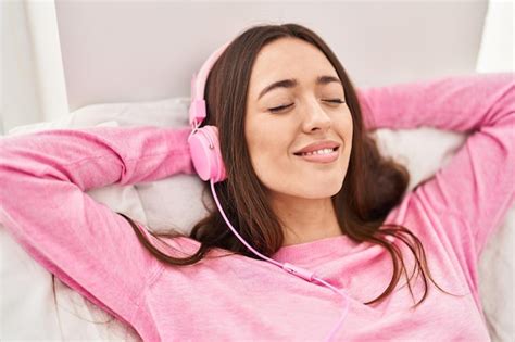 Premium Photo Young Beautiful Hispanic Woman Listening To Music Lying