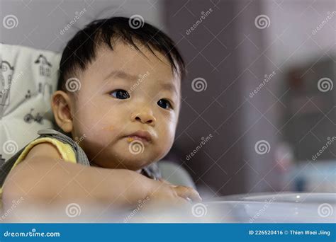 Adorable And Cute Happy Asian Chinese Baby Boy Siting On Baby Chair