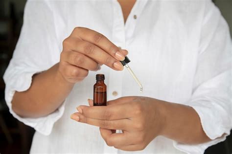 Premium Photo A Woman Holding A Small Bottle Of Essential Oil